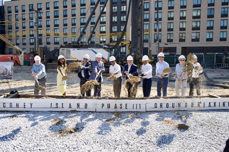 mayor adams and partners posing with shovels in front of building