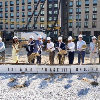 mayor adams and partners posing with shovels in front of building